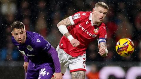 James McClean of Wrexham is challenged by Kane Smith of Stevenage 