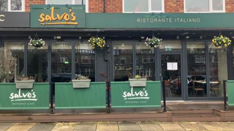 Salvo's Italian restaurant and bar in Leeds, which has a glass font and dark green signage with yellow writing.
