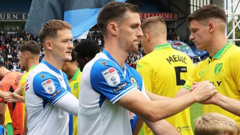 Dom Hyam shakes hands with Norwich players before their Championship match