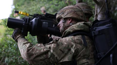 A British soldier demonstrates using a new weapon.