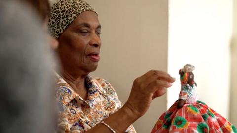 A woman with dementia admiring an African doll