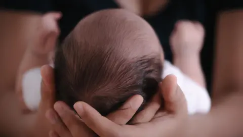  Close-Up of Mother Holding Newborn Baby in Living Room