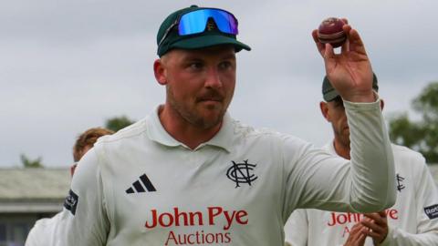 Liam Patterson-White leaves the outfield with the ball after taking five wickets against Leicestershire