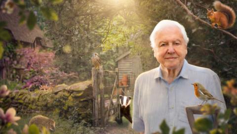 Sir David Attenborough stands in a garden surrounded by various animals including a squirrel, badger and hedgehog
