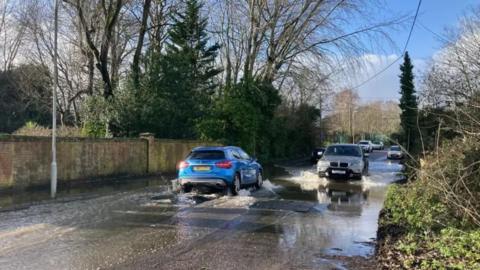 Cars passing each other on a  flooded road