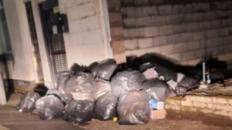 Bin bags piled up on Moore Street in Bootle 