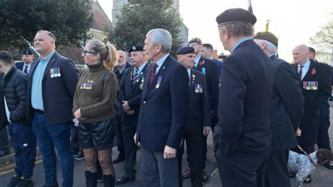 A group of people gather wearing military uniforms.