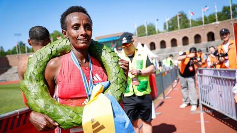 Shewarge Alene has a green wreath around her neck 
