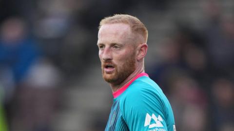 Liam Stanley during an away match last season for Harrogate, wearing a teal-coloured kit