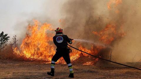 Firefighter tackling a fire in Greece.