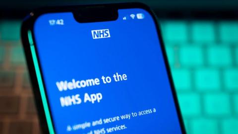 A phone with a blue screen on it. The screen has white writing on reading "Welcome to the NHS app".