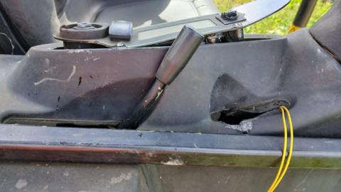 A close up image of the digger's cabin showing scratch marks and wires that have been pulled out.