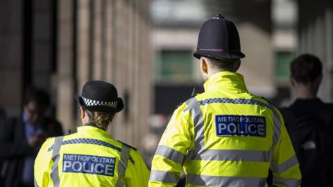 Rear view of Met police officers on patrol in London