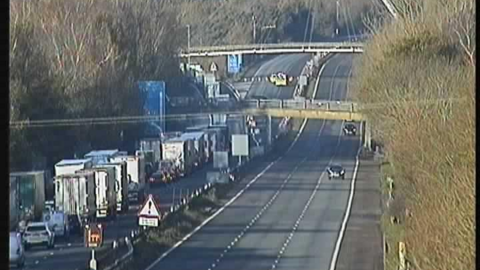 A picture from a camera on a motorway with traffic one carriageway and an empty carriageway on the other side.