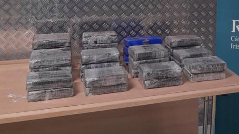 The suspected cocaine pictured in square packages on a table beside an Irish Revenue sign 