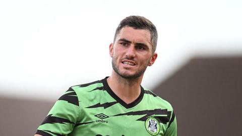 Jordan Moore-Taylor clenches his teeth in determination on the field for Forest Green Rovers