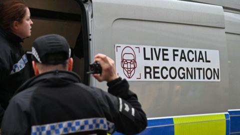 A picture of police officers include a live facial recognition van in Essex. 