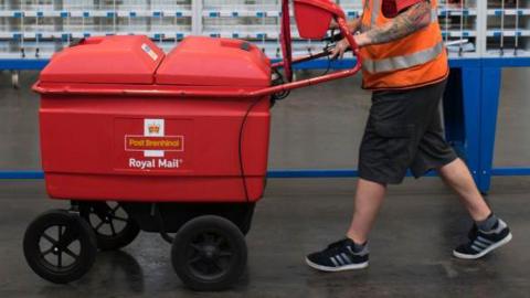 A worker pushes a trolley at the Royal Mail sorting office on Penarth Road on May 15, 2017 in Cardiff, United Kingdom