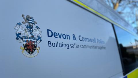 The outside of a Devon and Cornwall Police van on a bright sunny day. 