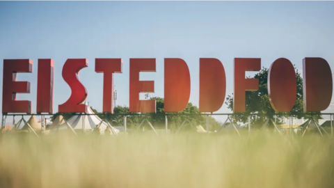 eisteddfod sign in bold red lettering in long grass
