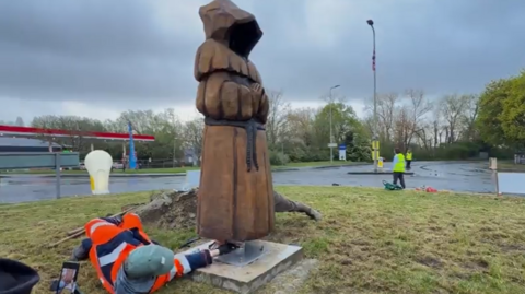 A statue of a monk, carved out of English oak on a roundabout in Abingdon.