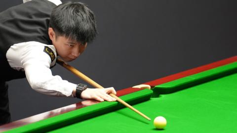 Zhao Xintong plays a shot