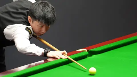 Zhao Xintong plays a shot