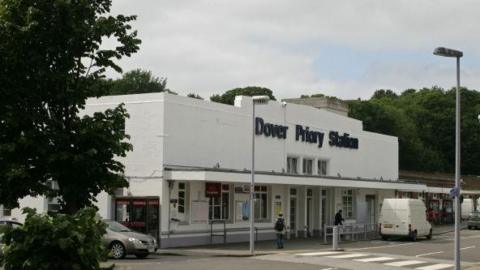 A picture of the front of Dover Priory Station - a white building with black lettering.