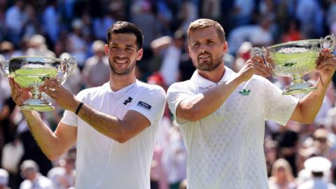 Julian Cash (left) and Lloyd Glasspool pose with their Wimbledon doubles trophies