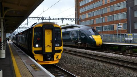 Two Great Western Trains, including an IET, stopped in adjoining platforms at Swindon Station.