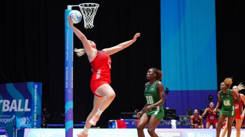 Eleanor Cardwell shooting into the basket for England during their netball match against Malawi at the Commonwealth Games in Glasgow