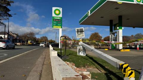 The BP garage on the A167 at Ferryhill. Several vehicles are parked at petrol pumps. The building has green BP branding and a low white wall runs along the front.