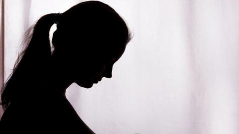 Stock image of woman's black silhouette looking down