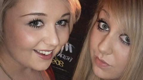 A selfie photo of two blonde girls. They are both wearing lots of make up and smiling at the camera.