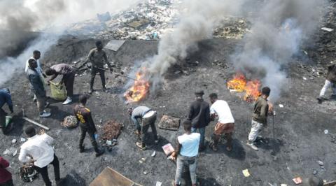 Men at the Agbobloshie dump burning cables and plastic.