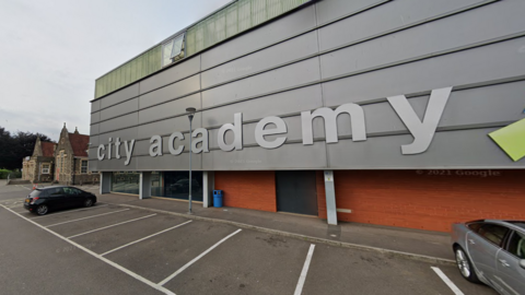 Google image of the outside of City Academy - a building with the silver, metal clad exterior with 'city academy' written in silver letters.