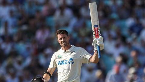 Henry Nicholls raises his bat with his helmet in his hand after his century