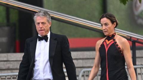 Hugh Grant arrives at Madison Square Garden with his partner.