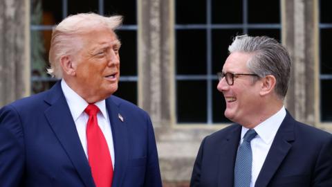 US President Donald Trump with British Prime Minister Sir Keir Starmer in September 2025. Trump wears a blue jacket, red tie and a gold pin featuring the American flag. Starmer wears a blue jacket, blue patterned tie and his customary black-rimmed glasses.