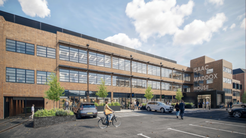 The outside of Shrub Hill Quarter building which is full of windows and has cars parked in front. A cyclist is using the road and holding a bag