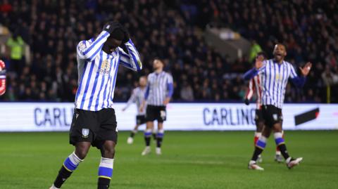 Djeidi Gassama with his head in his hands while playing for Sheffield Wednesday