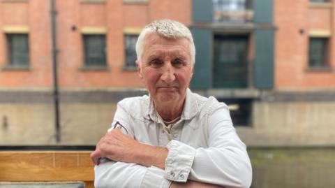 John Bann standing on the deck of his narrowboat