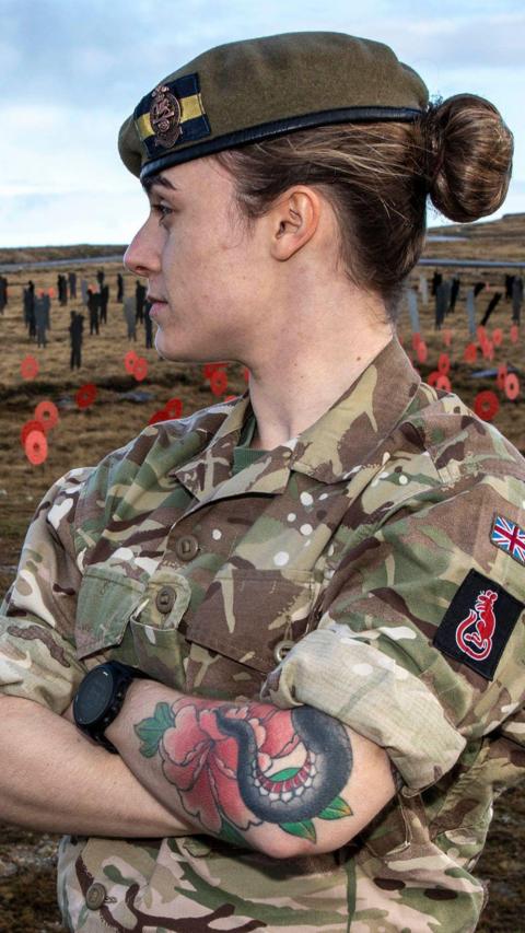 A woman wearing military uniform looking over her shoulder.