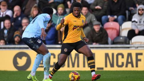 Bobby Kamwa of Newport County is challenged by Tyrell Warren of Grimsby Town