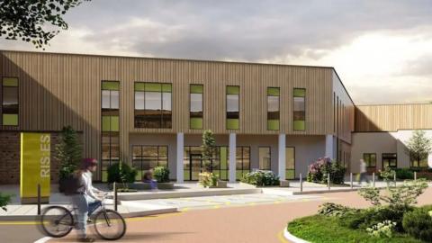 An artist's impression of what the hospital could look like. It is s two-storey building with light wooden cladding on the outside. There is a person in the foreground riding a bicycle. 