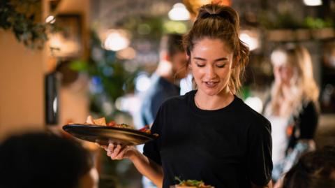 Woman waiter serving in a restaurant