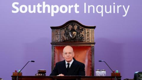 Chair Sir Adrian Fulford sits inside a hearing room at Liverpool Town Hall