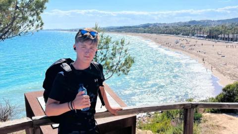 Henry Moores clutching a water bottle as he walks through Spain