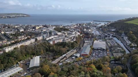 An expanse of rooftops across Douglas, with the bay in the background and Onchan Head to the left.