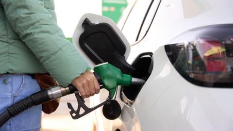 Close-up of a woman hand fueling tank of car - stock photo